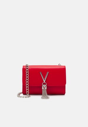 Borsa a tracolla in pelle rossa con catena argentata, caratterizzata da un accento a forma di V e un dettaglio con nappina metallica. Texture liscia e design strutturato.