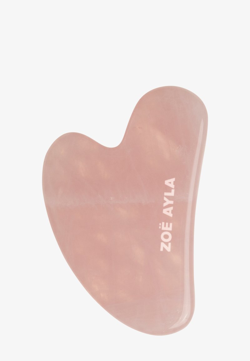 Outil de massage facial gua sha en quartz rose lisse et poli avec des bords incurvés, gravé du nom de la marque « Zoë Ayla ».