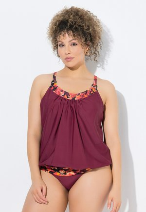 Maroon tankini-toppi, jossa on kukkakuosiset reunat, pleatattu muotoilu ja ohuet olkaimet; yhdistettynä yksivärisiin marooniin bikineiden alaosiin. Pehmeä, kevyt materiaali.