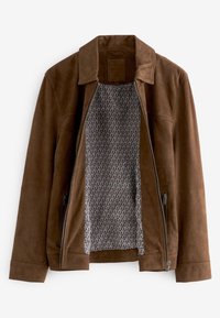 Chaqueta de ante marrón con cuello, cremallera delantera abierta que revela un forro de patrón geométrico en blanco y negro, y bolsillos laterales con cremallera.