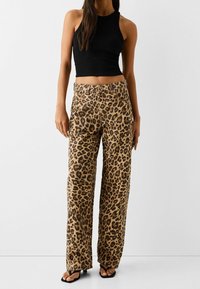 Leopardprint wijde broek in tan en zwart, met een hoge taille, zijzakken en een comfortabele pasvorm. Gemaakt van zachte stof.