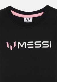Svart bomull T-skjorte med rund hals, rosa innerfôr og en fremtredende hvit "MESSI" logo med rosa detaljer på venstre side.