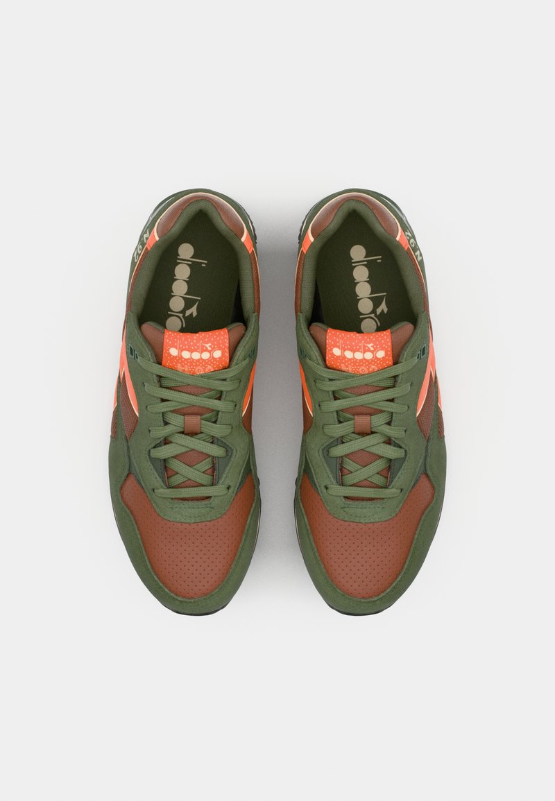Sneaker mit grünem und braunem synthetischem Obermaterial, orangefarbigen Akzenten, perforierter Textur an der Zehe und Schnürverschluss. Mit Logo auf der Zunge.