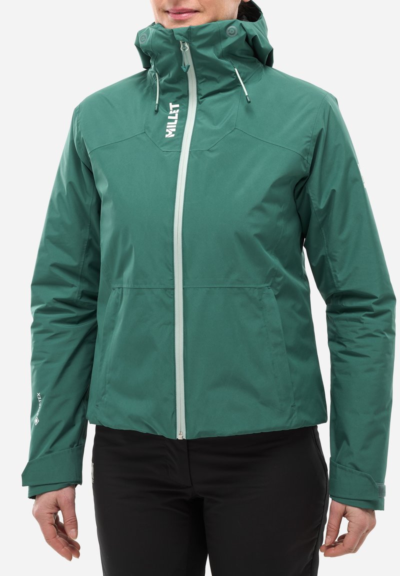 Veste imperméable verte avec fermeture éclair à l'avant, capuche ajustable et poignets élastiques, présentant une texture lisse et des accents de design minimalistes.