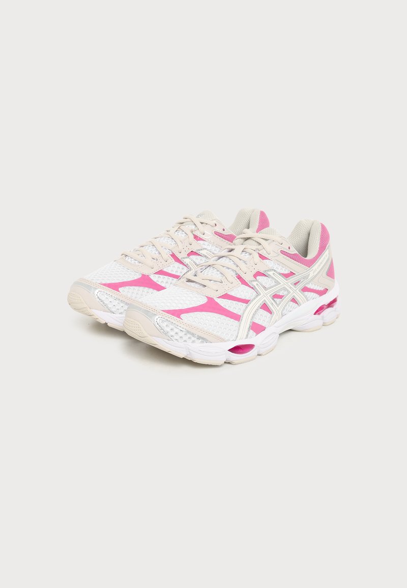 Paar weiße und pinke Laufschuhe mit beigen Schnürsenkeln und gepolsterten Sohlen auf einem schlichten hellen Hintergrund.