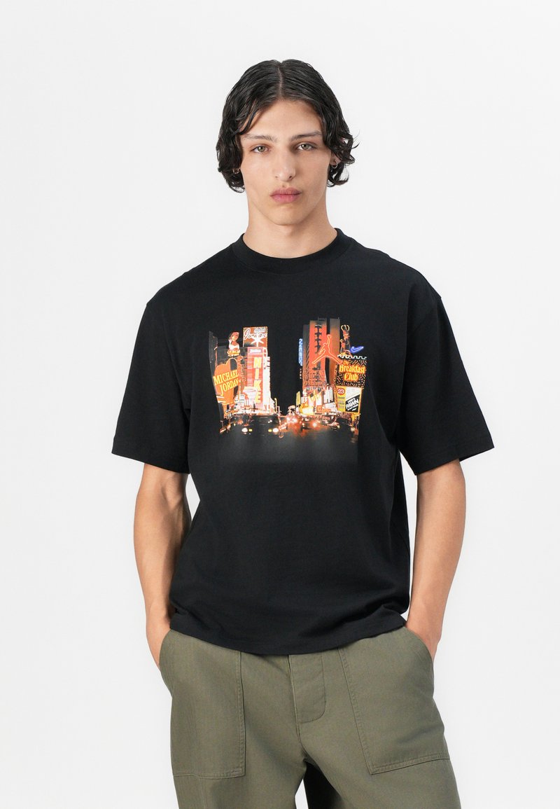 Czarny t-shirt z krótkim rękawem z dynamicznym nadrukiem Times Square z kolorowymi billboardami i światłami, wykonany z materiału bawełnianego.
