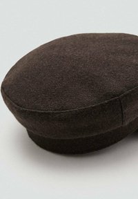 Bruine vilten pet met een ovale vorm en een vlakke bovenkant, met een gladde textuur en subtiele stiksels langs de rand.