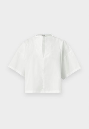 Hvit damebluse med korte ermer, V-hals og løs, firkantet passform, vist på ensfarget bakgrunn.