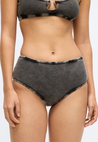 Μαύρο και μπεζ ριγέ μαγιό σλιπ με ψηλή μέση, ομαλή υφή και αντίθετα περιθώρια. Διαθέτει σχεδιασμό μέσης για άνεση.