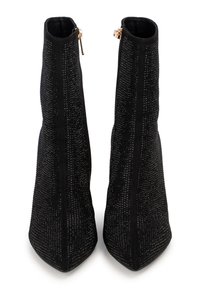 Botas de tobillo negras con una superficie texturada y brillante, con punta afilada y cremallera lateral. Tacón elevado y estructurado para mayor soporte.