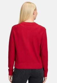 Czerwony sweter o fakturze z okrągłym dekoltem i długimi rękawami. Posiada ribbowe wykończenie u dołu i przy rękawach, zaprojektowany z gładkim, miękkim wykończeniem.