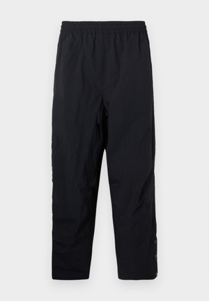 Svarta elastiska midjebandbyxor med raka ben och tryckknappar vid ankeln på en plain vit bakgrund.