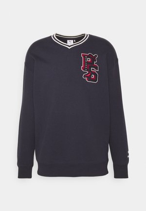 Tamsiai mėlynas džemperis su V formos iškirpte, gipiūro apykakle ir siuvinėtu "P6" logotipu raudonai ir baltai. Minkšta tekstūra, ilgos rankovės ir elastingas apatinis kraštas.