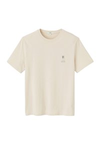 T-shirt à manches courtes beige clair en coton, avec un petit imprimé graphique sur la poitrine gauche. Col rond et coupe décontractée.