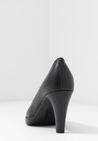 Černá kožená lodička na vysokém podpatku se zaoblenou zadní částí a hladkým povrchem, vyfotografovaná na bílém pozadí s rohy.
