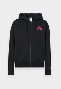 Čierna mikina na zips s prednými vreckami, kapucňou so sťahovacou šnúrkou a ružovým logom Nike SB na hrudi, pričom malé biele logo je na manžete ľavého rukáva.