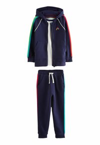 Granatowy hoodie z tęczowymi paskami na rękawach oraz niewielkim haftem tęczy. Dopasowane spodnie dresowe mają boczne kieszenie i elastyczny pas.
