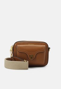 Ruskea nahkainen olkalaukku, jossa etutasku, kullanväriset metalliosat ja beige kangasolkaiminen hihna. Siinä on valkoiset tikkaukset.