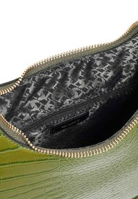 Green crocodile-patterned leather bag interior with a black fabric lining featuring a subtle pattern and a zippered compartment. Gold zipper detail.