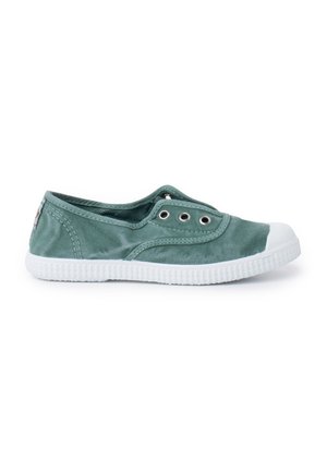 Baskets slip-on en toile verte avec semelle en caoutchouc blanc et capuchon en caoutchouc, dotées d'œillets en métal et de coutures sur le dessus.