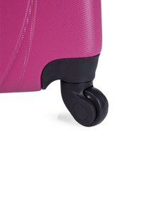 Maleta dura rosa con una superficie texturizada, ruedas de plástico negro y un diseño de esquinas redondeadas para una mejor maniobrabilidad.