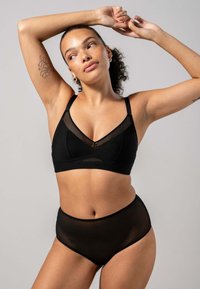 Svart lyxunderställ som inkluderar en mesh-bralette med V-ringning och högmidjade trosor, båda i en genomskinlig textur.