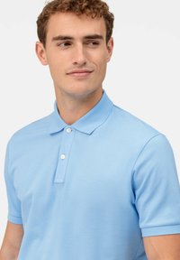 Polo shirt azzurro chiaro in cotone, con colletto classico, tre bottoni e maniche corte con finitura testurizzata.