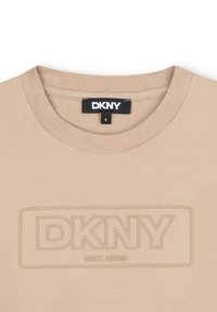 Beige DKNY t-shirt met ronde hals, tekstuur logo in een rechthoekige omtrek, en etiket met maat 8. Glad katoen stof.