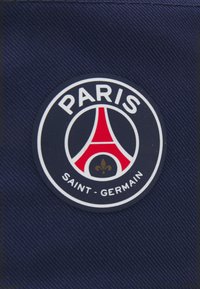 Rund stoffmerke med en marineblå bakgrunn, som har et rødt Eiffeltårn, hvit tekst "PARIS" og "SAINT-GERMAIN," samt en gyllen lilje.
