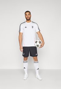 Juventus futbola iegūšana ir balta kreklā ar melniem akcentiem un zaļiem elementiem, kas apvienota ar melnām biksēm un baltām zeķēm ar melnām svītrām.