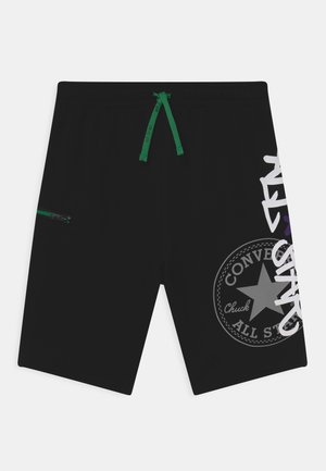 Short noir avec cordon vert, poche latérale zippée et logo blanc Converse Chuck Taylor All Star sur la jambe droite.