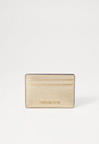 Portofel de carduri din piele aurie cu suprafață texturată, patru sloturi pentru carduri și logo-ul embosat "MICHAEL KORS" în partea de jos. Formă rectangulară.