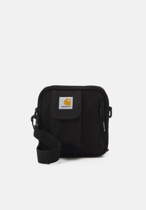 Sort Carhartt crossbody taske med frontlomme, lynlåslomme og justerbar skulderrem på ens hvid baggrund.