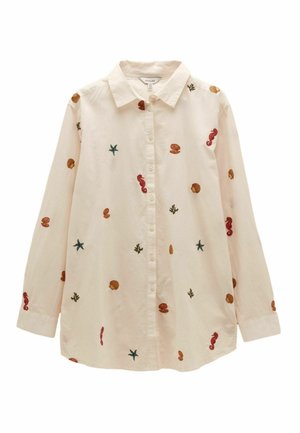 Chemise beige à manches longues boutonnée avec des motifs marins brodés, y compris étoiles de mer, hippocampes, coquillages et corail, étalée à plat.