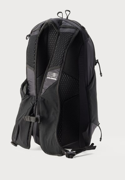 Μαύρο σακίδιο πλάτης Salomon με επενδεδυμένους ιμάντες ώμων από διχτυωτό υλικό και πίνακα στην πλάτη, μικρές πλαϊνές τσέπες και ρυθμιζόμενους ιμάντες στο στήθος και στη μέση.