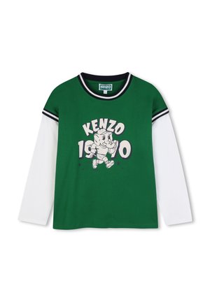 Chemise verte à manches longues avec manches blanches, col et poignets rayés noir et blanc, avec un éléphant en train de courir et le texte "KENZO 1970".