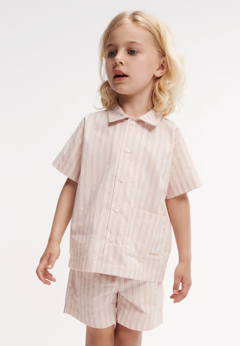 Chemise à manches courtes rayée rose et blanche avec un col et une poche frontale, assortie à un short, fabriquée en tissu léger.