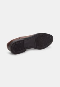 Scarpa in pelle marrone con suola in gomma nera texturizzata, caratterizzata da un designpiatto e linee pulite. La suola presenta un motivo a battistrada per una migliore aderenza.