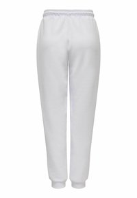 Witte joggingbroek van zacht materiaal, met een elastische band en aansluitende boorden. Gladde textuur zonder zichtbare patronen of details.