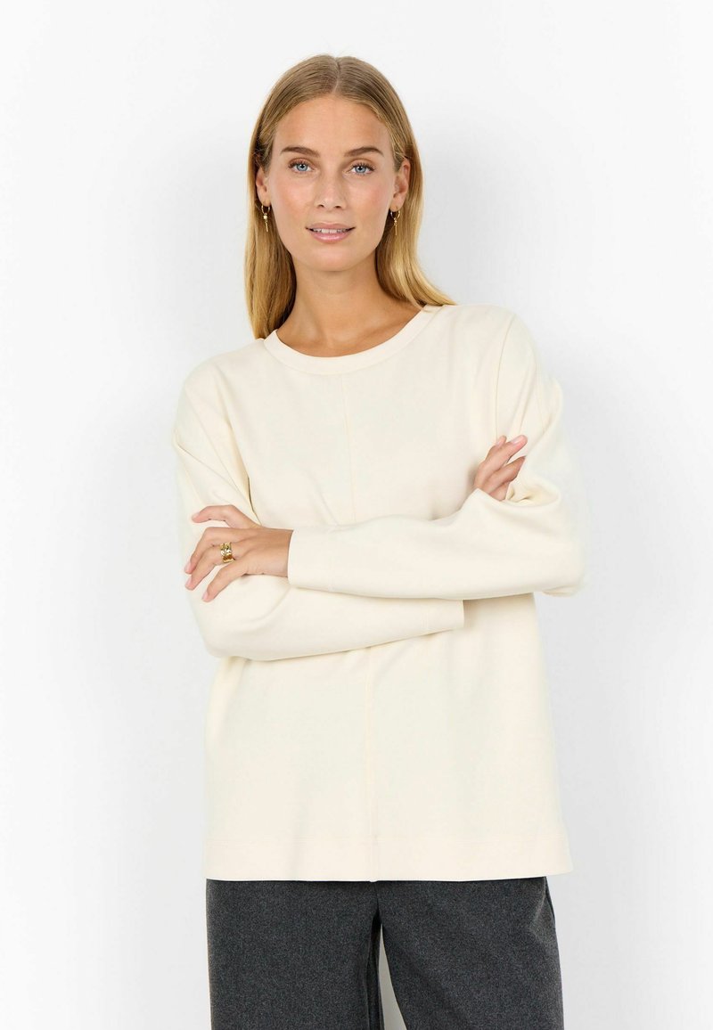 Sweatshirt de culoare crem, cu guler rotund, manșoni lungi și un croi relaxat. Prezintă un material moale și detalii subtile de cusătură.