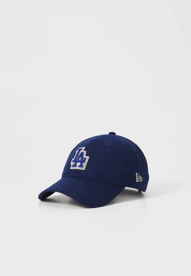 Navy blue baseball cap made of felt with embroidered "LA" logo in blue and white. Features a curved brim and side logo detail.