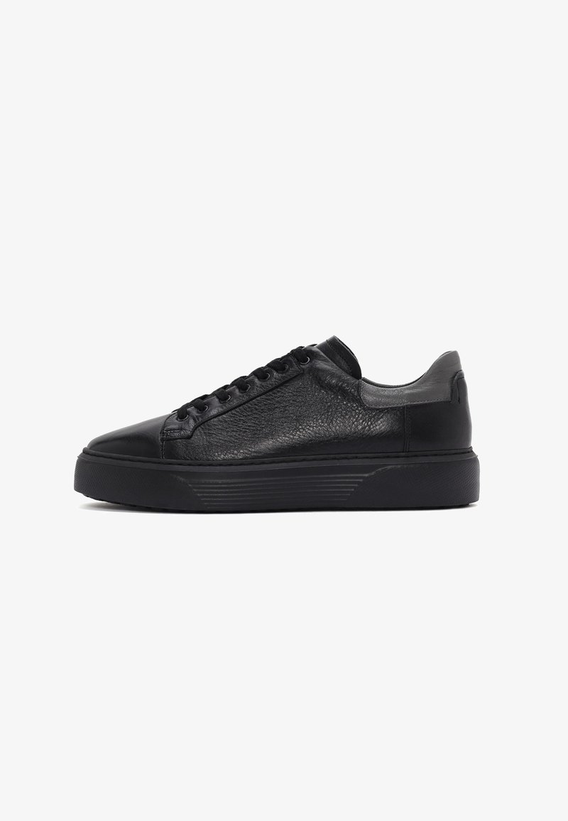 Czarne skórzane sneakersy z teksturowaną cholewką, zaokrąglonym noskiem, sześcioma oczkami i grubą gumową podeszwą z poziomymi rowkami.