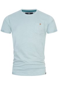 Himmelblaues Baumwoll-T-Shirt mit kurzen Ärmeln, rundem Halsausschnitt und einer kleinen Brusttasche mit einem Holzknebeldetails.