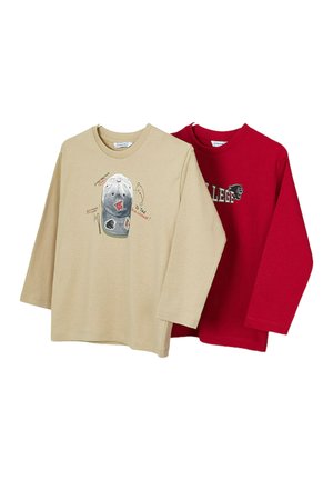 Due camicie a maniche lunghe: una beige con un design grafico che presenta un cappello e una rossa con la scritta "COLLEGE". Materiale in cotone, vestibilità comoda.