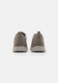 Grå nett såler med lav profil, med en solid beige såle og plukkebånd på hælen for enkel påkledning. Teksturert overflate for god pusteevne.