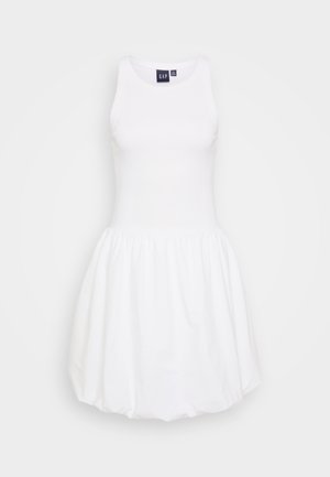 Bijela haljina bez rukava s uskim gornjim dijelom i naboranim, lepršavim suknjom. Izrađena od mekog materijala, s okruglim izrezom i bez vidljivih uzoraka.