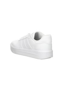 Zapatilla deportiva blanca con material sintético suave, perfil bajo, suela de goma plana y tres rayas paralelas en relieve en el lateral.