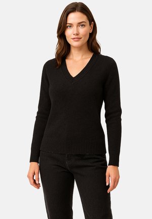 Schwarzer V-Ausschnitt-Pullover aus weichem Strickstoff. Mit gerippten Bündchen und Saum, schlanker Passform und strukturiertem Stichdetail entlang des Ausschnitts.