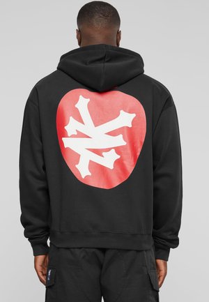 Schwarzer Hoodie mit rographic, die wie ein Herz geformt ist, und einem weißen abstrakten Design. Das Material ist weich, mit einem Standard-Schnitt und gerippten Bündchen.