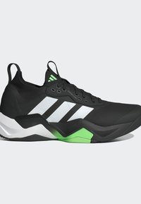 Chaussure de sport noire avec un dessus texturé, accents verts et blancs, trois rayures blanches, semelle légère et col rembourré pour le soutien.